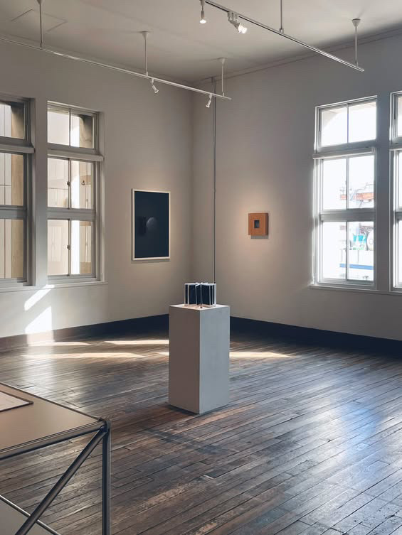展示室の全景 壁の額装作品と台座の作品