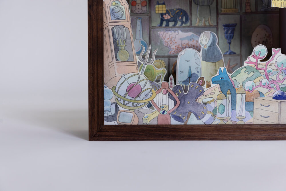 額縁の下部　手前に重ねられた振り子時計や天球儀などの魔法具の絵